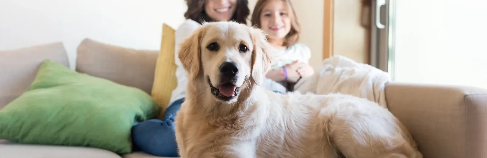 mother daugher and dog on couch