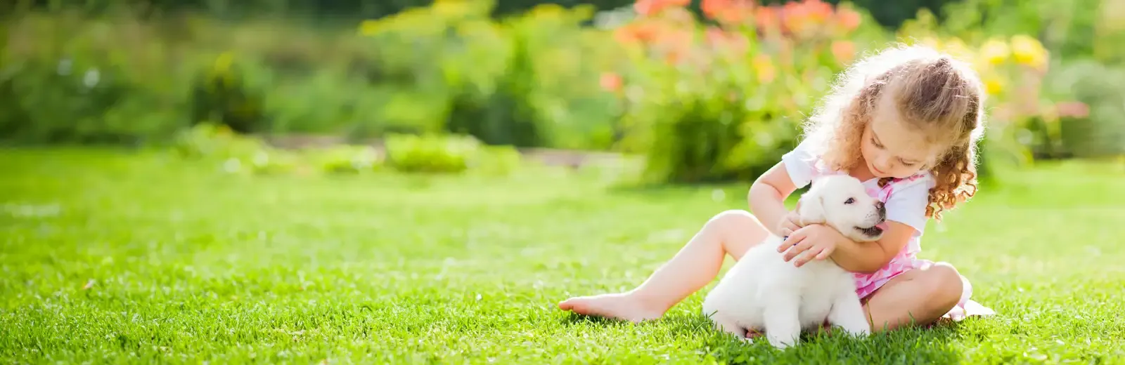 girl and puppy outside on lawn
