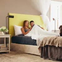 couple talking with dog in bed